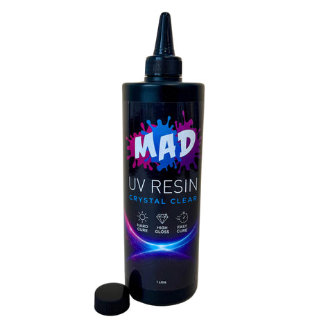 A 1 liter bottle of MAD UV RESIN Crystal Clear UV Resin with a black cap, shown on a plain white background with its cap placed beside the bottle and nozzel on.